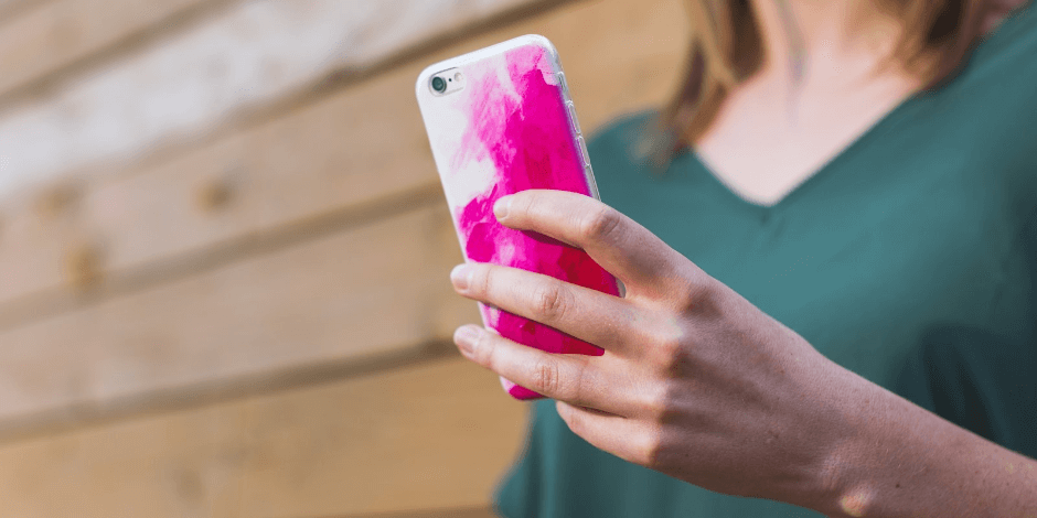 woman holding pink iPhone