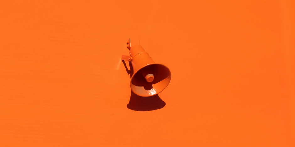 Orange megaphone on an orange wall