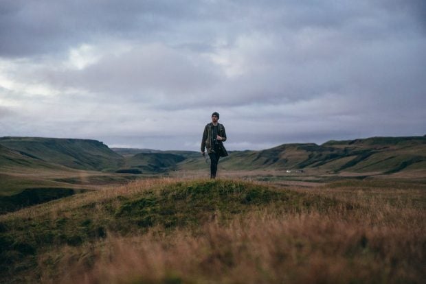 man standing in a hilly landscape