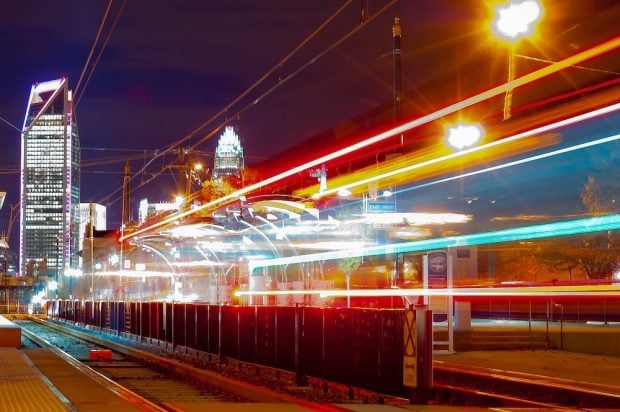 Lights at a train station with city in the background